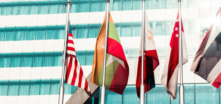 Flaggen vor einem Bürogebäude: Wie sollte internationales Recruiting organisiert sein: zentral oder dezentral? Internationales Recruiting