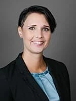 Verena Leisser, schwarze Jacke, hellblaues Top, lacht